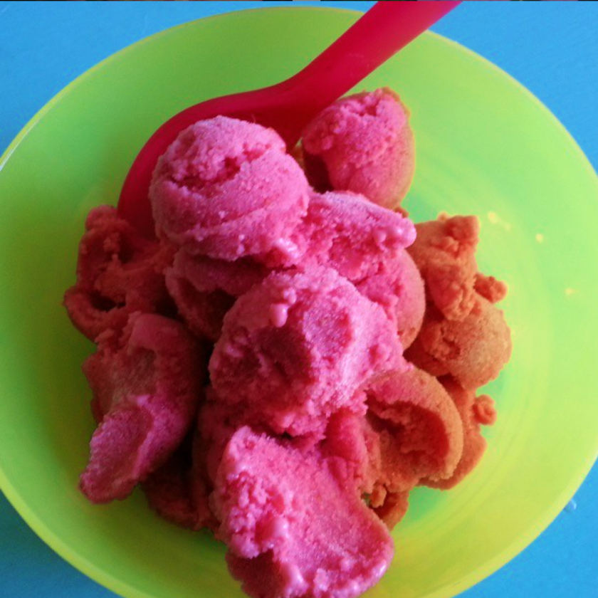 colouful bowl with scoops of frozen yoghurt with fresh strawberries